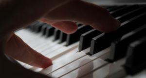 persons hand on piano keys