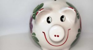 Ein mit Blumen verziertes Sparschwein mit lachendem Gesicht