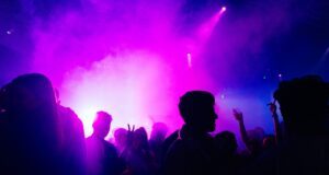 people standing on stage with purple lights