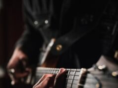 man playing guitar in close up photography