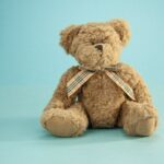 brown teddy bear on blue textile