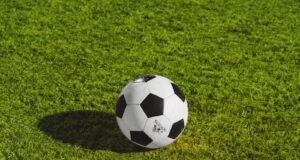 white and black soccer ball on grass field