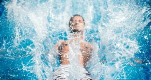 man falling on blue body of water