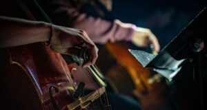 person in brown leather jacket playing brown and black drum set