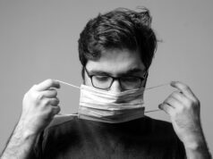 man in black crew neck shirt holding white paper
