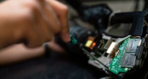 person holding green and black circuit board