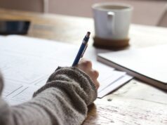 Saarland reformiert Förderschulen grundlegend person writing on brown wooden table near white ceramic mug