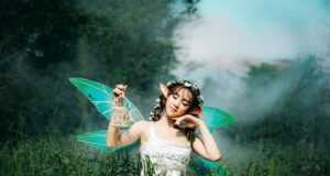 woman in white dress wearing green fairy wings