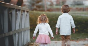 boy beside girl walking near railing