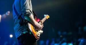 selective focus photography of man playing electric guitar on stage