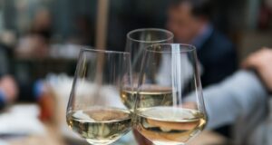 three people having a toast using three clear crystal wine glasses