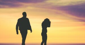 silhouette of man and woman under yellow sky