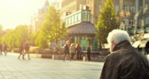 man sitting on brown wooden bench