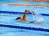 person swimming on an olympic pool