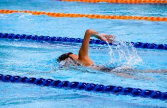 person swimming on an olympic pool