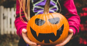 selective focus photography of person holding pumpkin