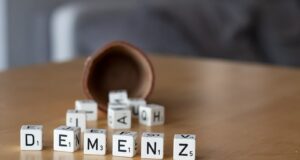 a wooden table topped with dices and letters