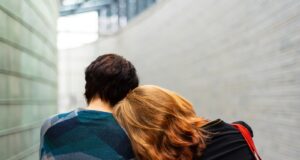 a woman rests her head on another person's shoulder