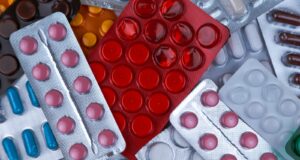 pile of blister packs of colorful medicine tablets