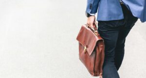 person walking holding brown leather bag