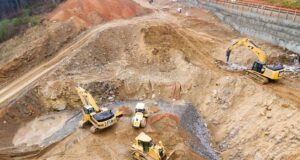 top view photography of four heavy equipment on quarry at daytime