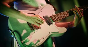 person playing white and brown stratocaster electric guitar