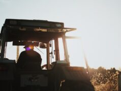 silhouette of man riding tractor