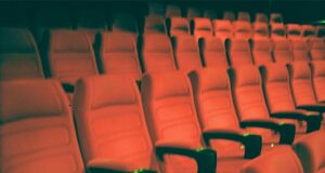 a row of empty red seats in a theater