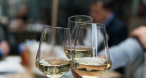 three people having a toast using three clear crystal wine glasses