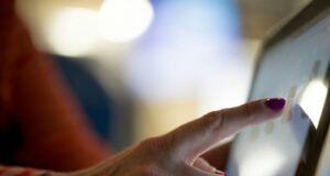 selective focus photography of person pointing at tablet computer
