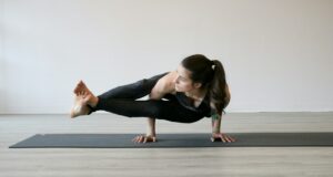 woman in black tank top and black leggings doing yoga