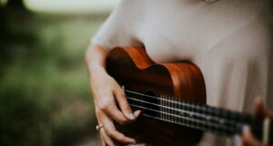 woman playing ukulele at daytime