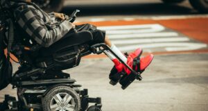 man in brown jacket and black pants riding black and red motorcycle