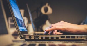 person using silver laptop computer on desk
