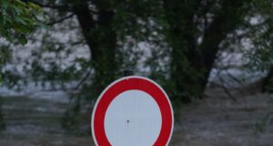 a street sign sitting in the middle of a flooded street