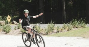 man in black jacket riding on black bicycle during daytime