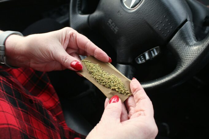 a woman holding a piece of marijuana in her hand