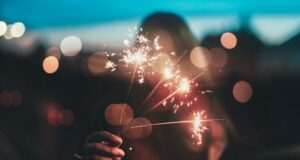 woman holding firework sticks in shallow photography