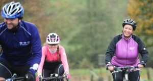 a couple of people riding bikes down a road