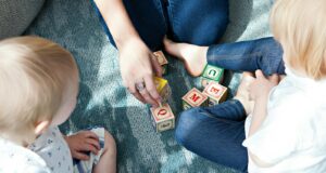 two toddler playing letter cubes