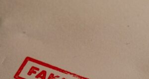 a stamp that reads fake news on a piece of paper