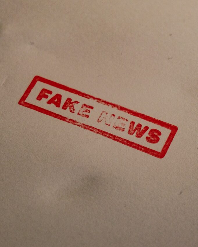 a stamp that reads fake news on a piece of paper