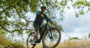 a man riding a bike down a dirt road