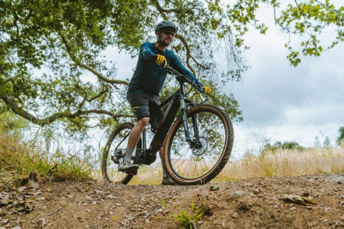 a man riding a bike down a dirt road