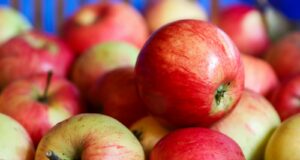a pile of red and green apples sitting on top of each other