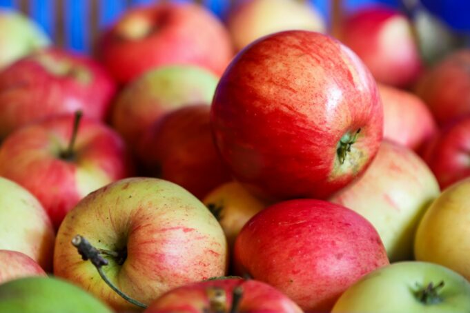 a pile of red and green apples sitting on top of each other