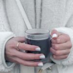 a woman holding a glass of wine in her hands