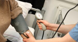 A person with a blood pressure device in their hand