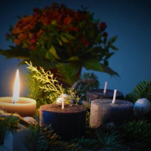 lighted candle beside another 3 candles