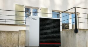 a white air conditioner sitting in front of a building